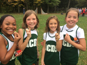 ACDS athletics four smiling female students in team uniform.