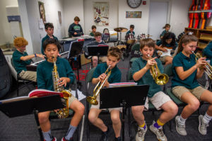 ACDS music students in band playing brass horn instruments