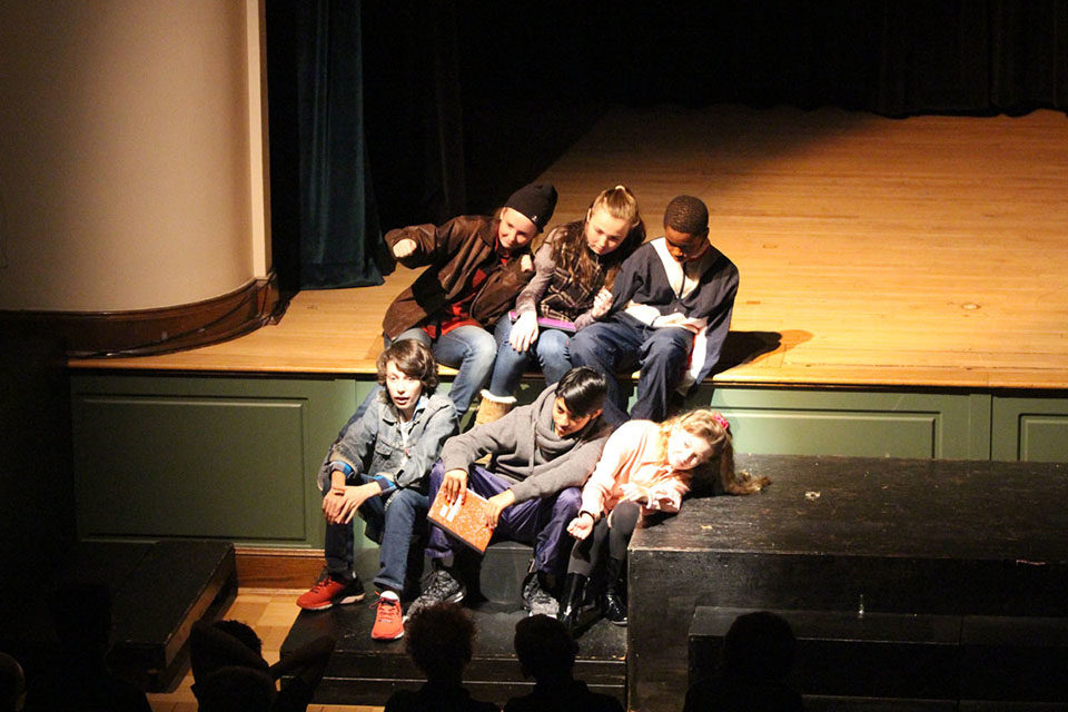 ACDS arts six students siting on steps on stage