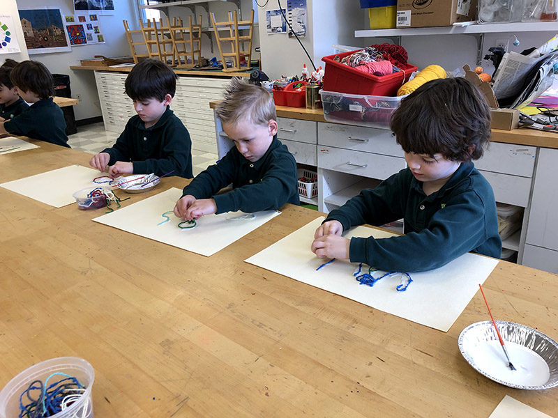 ACDS Lower School three boys drawing at table