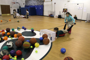 ACDS lower school students in gym playing with balls
