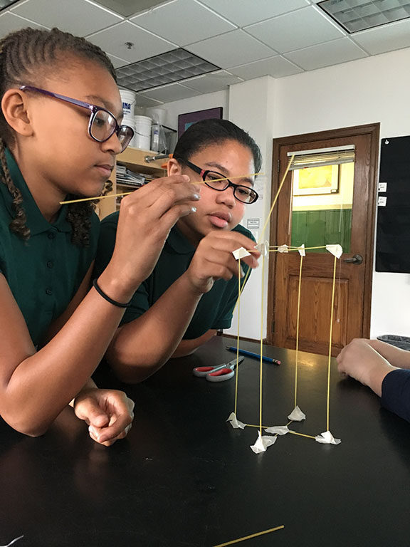 ACDS science two female students working on experiment with dry spaghetti