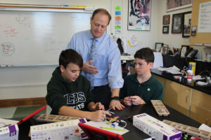 ACDS science male teacher with two male students working on science project